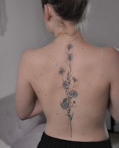 13 spine tattoos for women Flower Up Spine Tattoo, Spine Tattoos For Women Growth, Medium Spine Tattoos For Women, Midline Back Tattoo, Spine Tattoos Wildflower, Unique Tattoos Spine, Marigold Flower Spine Tattoo, Spinal Tattoo Floral