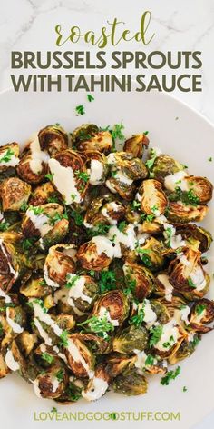 brussel sprouts with tahini sauce on a white plate, topped with parsley