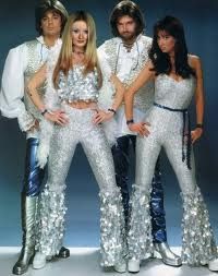 a group of people standing next to each other in front of a blue background wearing white outfits