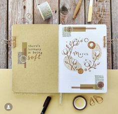 an open planner book sitting on top of a table next to a pair of scissors