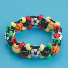 a close up of a bracelet made out of beads with sports balls and basketballs on it