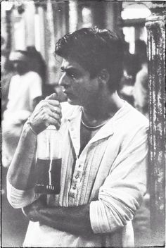 black and white photograph of a man holding a drink