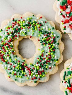 three decorated christmas sugar cookies with frosting and sprinkles