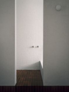 an empty bathroom with white walls and tiled floors