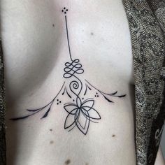 a woman with a tattoo on her chest has a flower in the shape of a heart