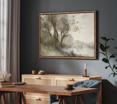 a painting hanging on the wall above a wooden table