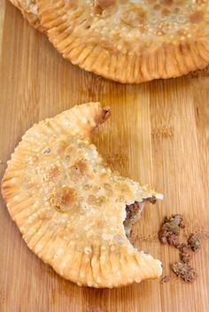 two pieces of pie sitting on top of a wooden cutting board next to each other