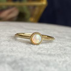 Handcrafted in 14K solid gold, features a 4mm round cab natural opal bezel set in a beautiful milgrain vintage style setting. A great everyday stacking ring or alternative gemstone engagement ring for your loved one! 🛠️ Setting: ✔️Metal Purity: 14K Solid Gold ✔️Color:  Yellow ✔️Band width: 1.5mm ✔️Ring sits 2.7mm on the finger 💎Center Stone: ✔️Stone: Natural Opal ✔️Shape: Round Cabochon ✔️Size: 4mm ✔️Carat: 0.25ct ❤️Visit our official website for exclusive new products.      https://elekalonjewelry.com/ ❤️Follow us on Instagram @ elekalonjewelry for the latest projects and much more! ❤️If you have any questions, please feel free to message us. . Gold Round Cut Opal Ring, Gold Opal Birthstone Ring, Gold Opal Ring With Birthstone, Gold Opal Ring Adjustable, Gold Adjustable Opal Ring, Round Shape, Adjustable Gold Opal Ring, Gold Opal Ring Fine Jewelry, Opal Ring With Bezel Setting, Opal Ring With Bezel Setting For Promise