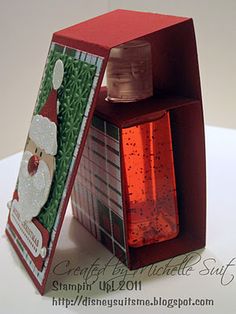 an open christmas card with a santa clause on it and a bottle in the corner