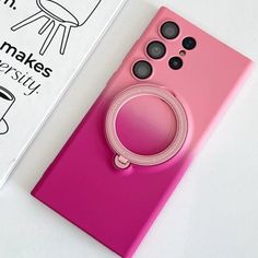 a pink cell phone sitting on top of a white table