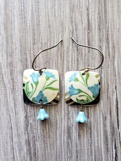 a pair of earrings with blue flowers on them