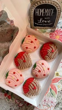 four decorated cookies in a box on a table