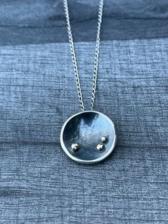 "This cup shaped, Sterling Silver pendant has been hammer-textured and oxidised. It was inspired by the orbiting planets in our solar system.  The planets have been depicted by 9ct gold high-polished spheres which contrast beautifully with the dark background.  The pendant measures approx: 1.8cm in diameter and hangs on an 18\" Sterling Silver chain.  'The Orbit Collection' also features a ring, studs and earrings. Please ask for details." Silver Celestial Round Necklace, Unique Hammered Round Pendant Necklace, Planets Necklace, Silver Electroformed Round Pendant Necklace, Sphere Necklace Pendants, Space-themed Silver Round Pendant Necklace, Modern Silver Sphere Necklace, Oxidised Necklace, Planet Jewelry