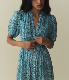 The Haleigh Dress—constructed from 100% organic cotton voile—features a high neck, mother-of-pearl buttons, and short puffed sleeves. Alternating panels of pintucks and ruching lend texture to the fitted bodice, which gives way to a tiered, ankle-grazing A-line skirt graced with clustered pintucks. Daisy Fields, Portugal Summer, Daisy Field, Casual Day Dresses, Classic Coats, Vintage Inspired Dresses, Family Beach, Blue Midi Dress, Cotton Voile