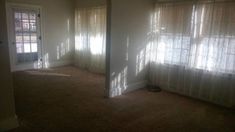 an empty room with sunlight coming through the windows