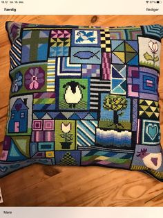 a colorful pillow on a wooden floor with an image of houses and trees in squares