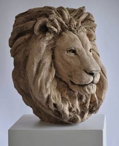 a sculpture of a lion's head sitting on top of a block of concrete