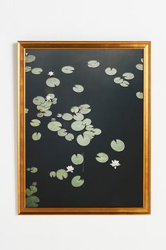 an image of water lilies floating in the pond on a black and gold frame