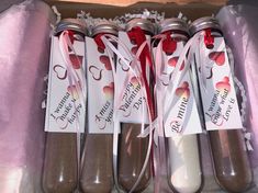 four spoons are sitting in a box with tags on them and ribbons tied around them