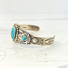 Vintage Old Pawn Sterling Silver Turquoise Cuff Bracelet - Applied Thunderbird - Hand Stamped Details - Arrows- Rising SunA gorgeous hand-crafted Navajo sterling silver and turquoise cuff bracelet. It is very well made with applied thunderbirds, studs, and many other hand-stamped details.The central oval turquoise cabochon measures 5/8 inch (17mm) by 7/16 inch (12mm).The two small round cabochons measure 1/4 inch (6mm) in diameter.It measures 5 1/4 inches long with a 1 1/2 inch gap at the bottom Southwestern Blue Nickel-free Cuff Bracelet, Southwestern Style Blue Nickel-free Cuff Bracelet, Southwestern Style Nickel Free Blue Cuff Bracelet, Southwestern Turquoise Cuff Jewelry, Unique Engraved Turquoise Bracelets, Handmade Southwestern Turquoise Cuff Bracelet, Stamped Turquoise Cuff Bracelet Gift, Vintage Nickel-free Turquoise Cuff Bracelet, Adjustable Southwestern Turquoise Cuff Bracelet