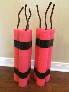 two pink vases with black ribbon on them sitting next to each other in front of a wall