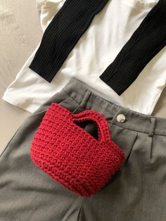 two pieces of clothing, one with a red handbag and the other grey pants