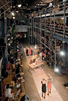 people are standing on the stage in front of an audience at a fashion show with lots of lights