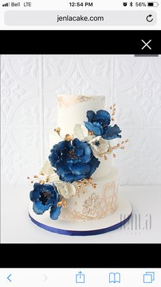 a white and blue wedding cake with flowers on it