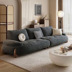 a living room with a gray couch and white rug on top of the wooden floor