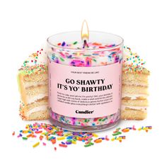 a birthday candle surrounded by sprinkles and cake slices on a white background