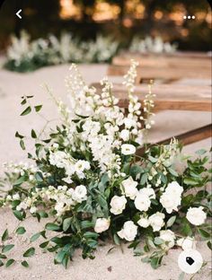 a bunch of white flowers sitting on top of a wooden bench