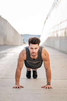 a man is doing push ups on his hands and knees in the middle of a sidewalk