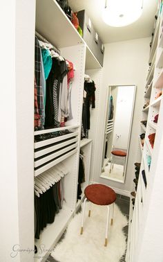 a walk in closet filled with lots of clothes