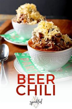 two bowls filled with beef chili on top of a table