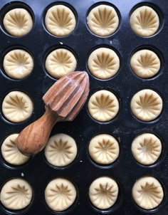 a wooden spatula sitting on top of an oven pan filled with cupcakes