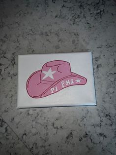 a pink hat with white stars on it sitting on top of a marble countertop