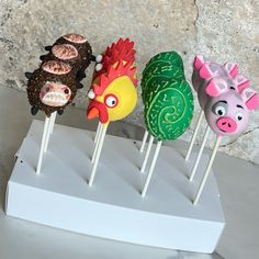 four cake pops decorated like farm animals on sticks