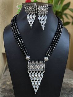 "Adorn your beautiful personality with this exquisitely designed and handcrafted beaded necklace and matching earrings combo set in high quality German Silver. Pair it up with any formal or semi formal attire and gather compliments at the next event! Necklace length 13.5 inches Necklace weight 102 GM's Earrings weight 34 GM's Length 2.7\" Width 1.2\" Note: All in stock items will be shipped from New Delhi, India within 2-3 business days after receipt of payment. International orders may take any Festive Silver Beaded Temple Necklace, Silver Beaded Kundan Necklace For Diwali, Festive Beaded Silver Jewelry Sets, Festive Silver Beaded Jewelry Sets, Traditional Festive Jewelry Sets With Silver Beads, Earrings Combo, Beautiful Personality, Semi Formal Attire, New Delhi India