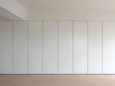 an empty room with white walls and wood floors