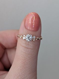 a woman's hand holding a diamond ring