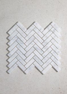 a white marble herringbone tile pattern on the floor