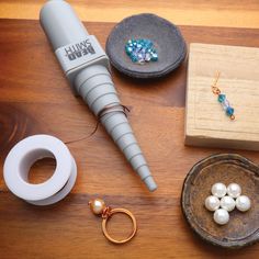 a table topped with jewelry and accessories on top of a wooden table next to a box