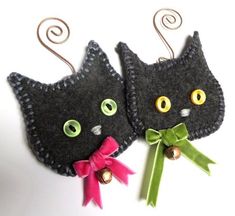 two black cats with green eyes and bows