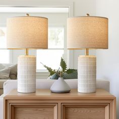 two lamps sitting on top of a wooden table