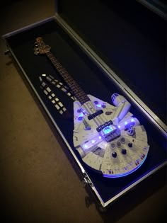 a white guitar with blue lights in a case