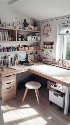 a desk with lots of crafting supplies on it in a room that has wooden floors