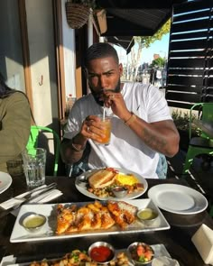 a man sitting at a table with food and drinks