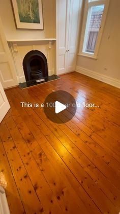 an empty room with wood floors and a fireplace