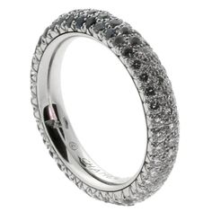 a white gold ring with black and white diamonds on the outside, set in 18k white gold