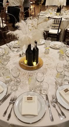 the table is set with white linens, silverware and place settings for dinner